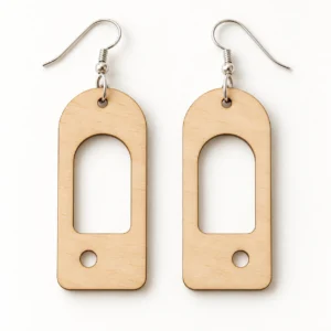 Illustrative wooden mockup of the Arc and Orbit geometric earrings SVG, showing two mirrored arch blanks with circular cutouts.